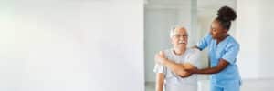 man doing arm stretches with the help of his care provider